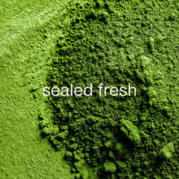 close-up of vibrant green matcha powder, freshly stone-ground, with text overlay: "sealed fresh"