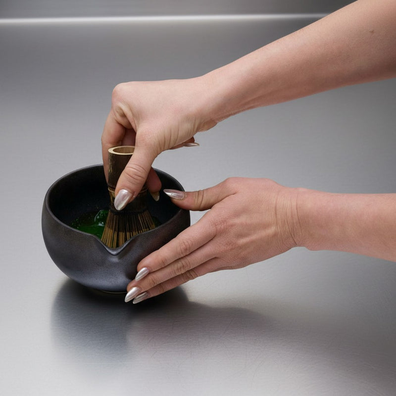 step 3: whisking matcha with a bamboo chasen in an M motion until frothy and smooth